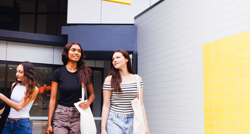Three university students gathering outside a student accommodation walking to class.